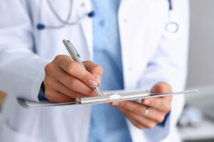 Doctor with pen and clipboard filling out a skilled nursing checklist