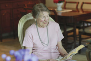 elderly woman reading a book in chair