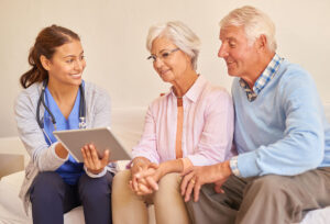 nurse talking with elderly couple about assisted living for those with different needs