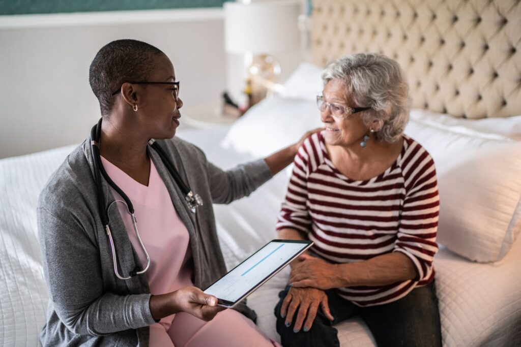 Skilled Nursing nurse consults with resident while holding a ipad.